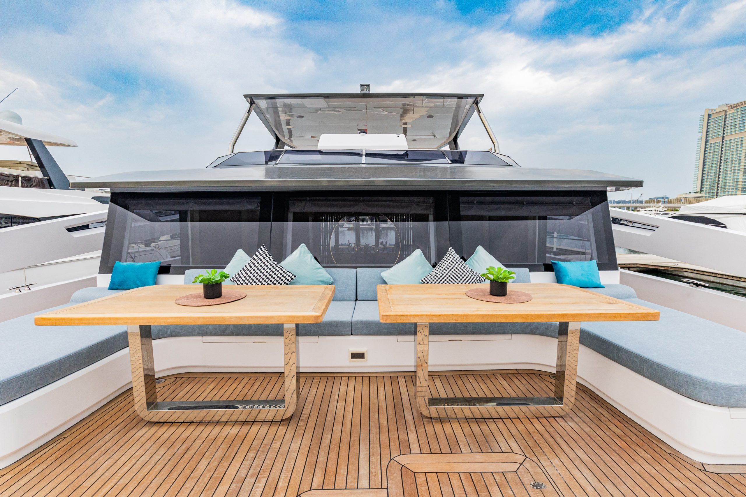 Zirve 72 yacht front deck seating with wooden tables and comfortable cushions