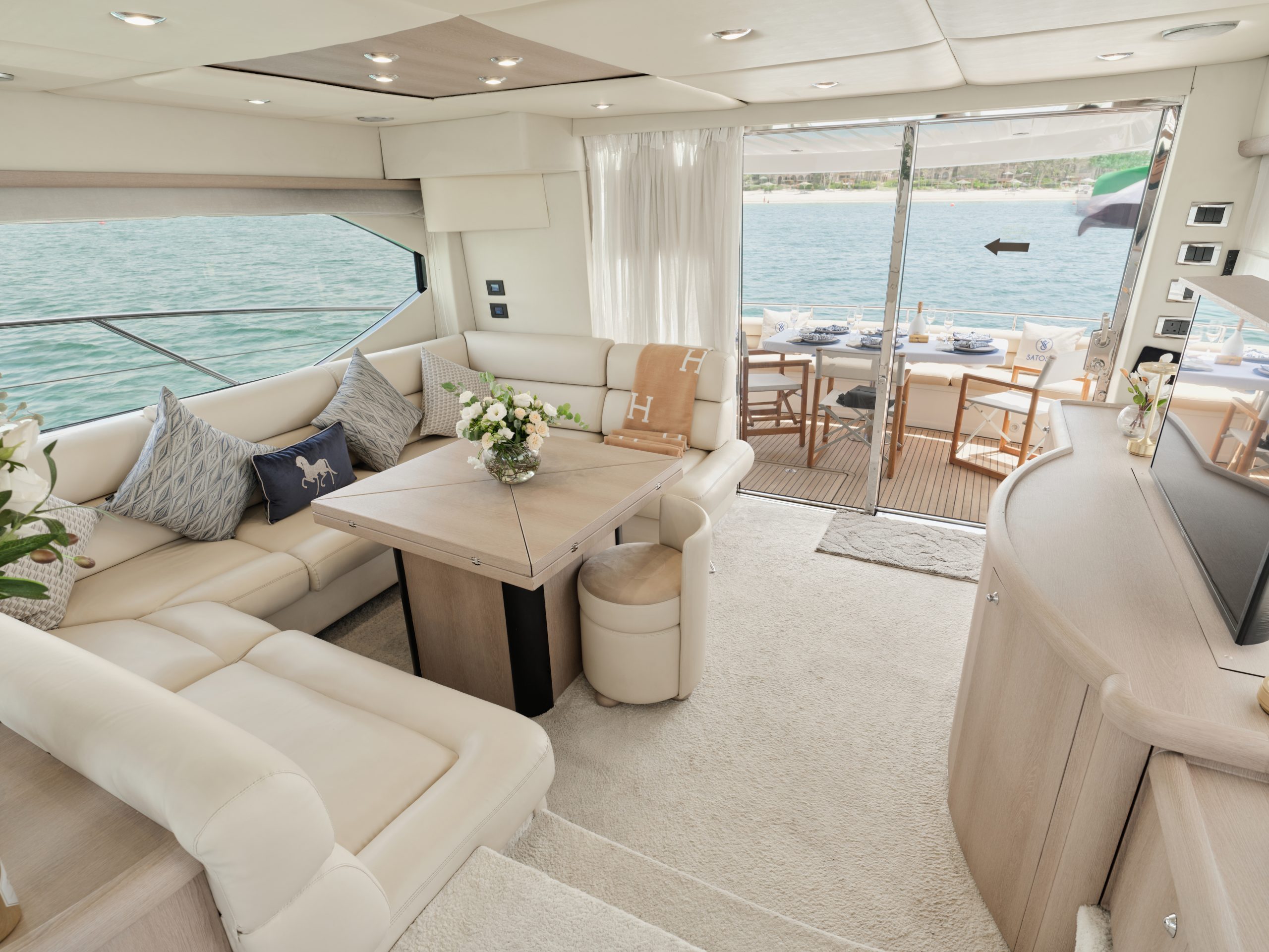 Luxury yacht interior dining area and lounge with cream leather seating and ocean views