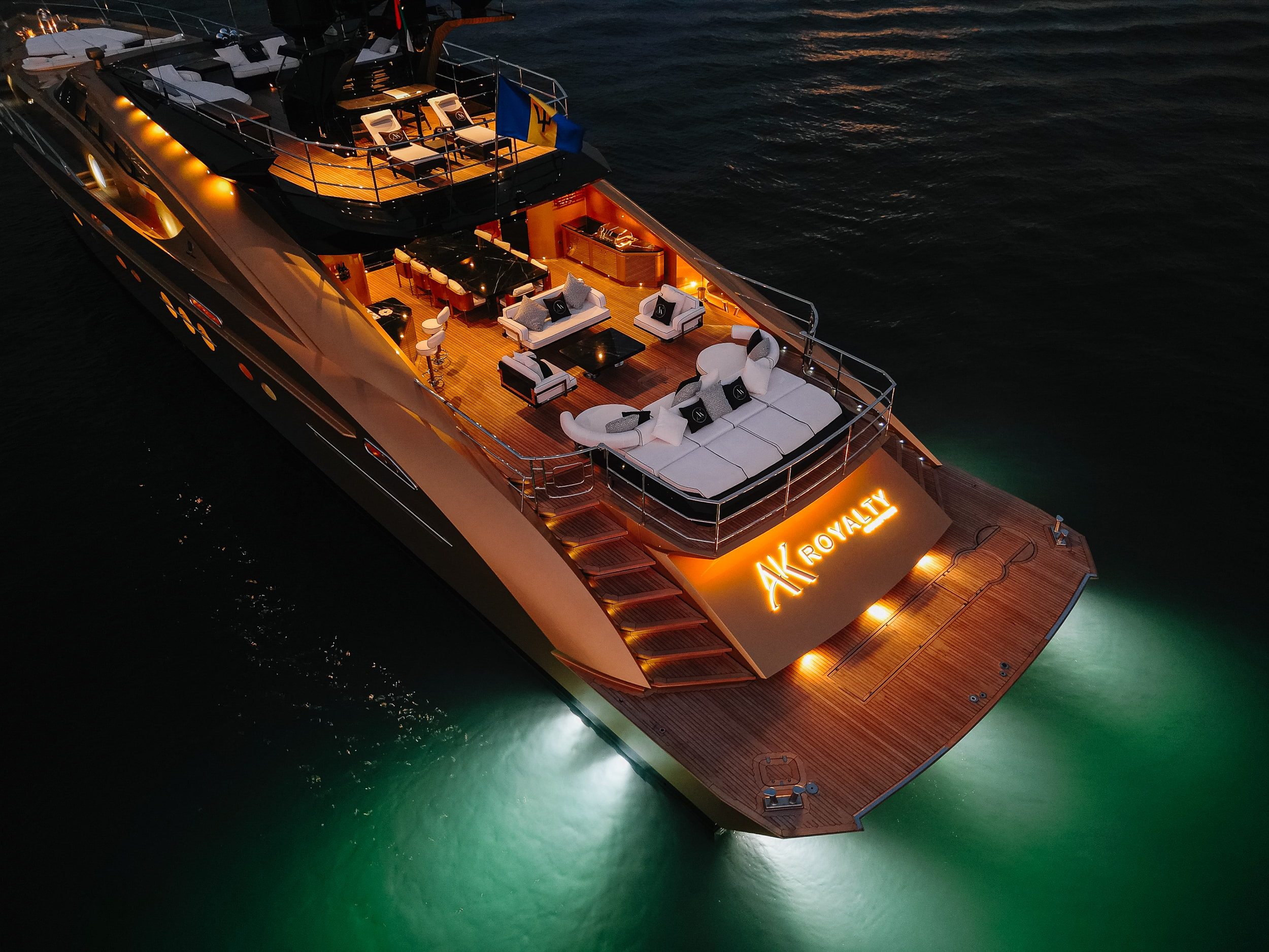 Royalty 136 luxury yacht illuminated at night with underwater lights glowing in the ocean