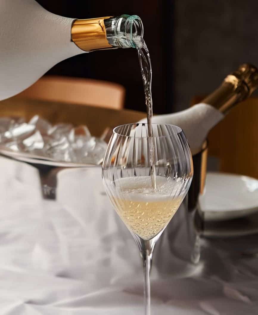 bartender pouring champagne into glass for luxury yacht service in Dubai