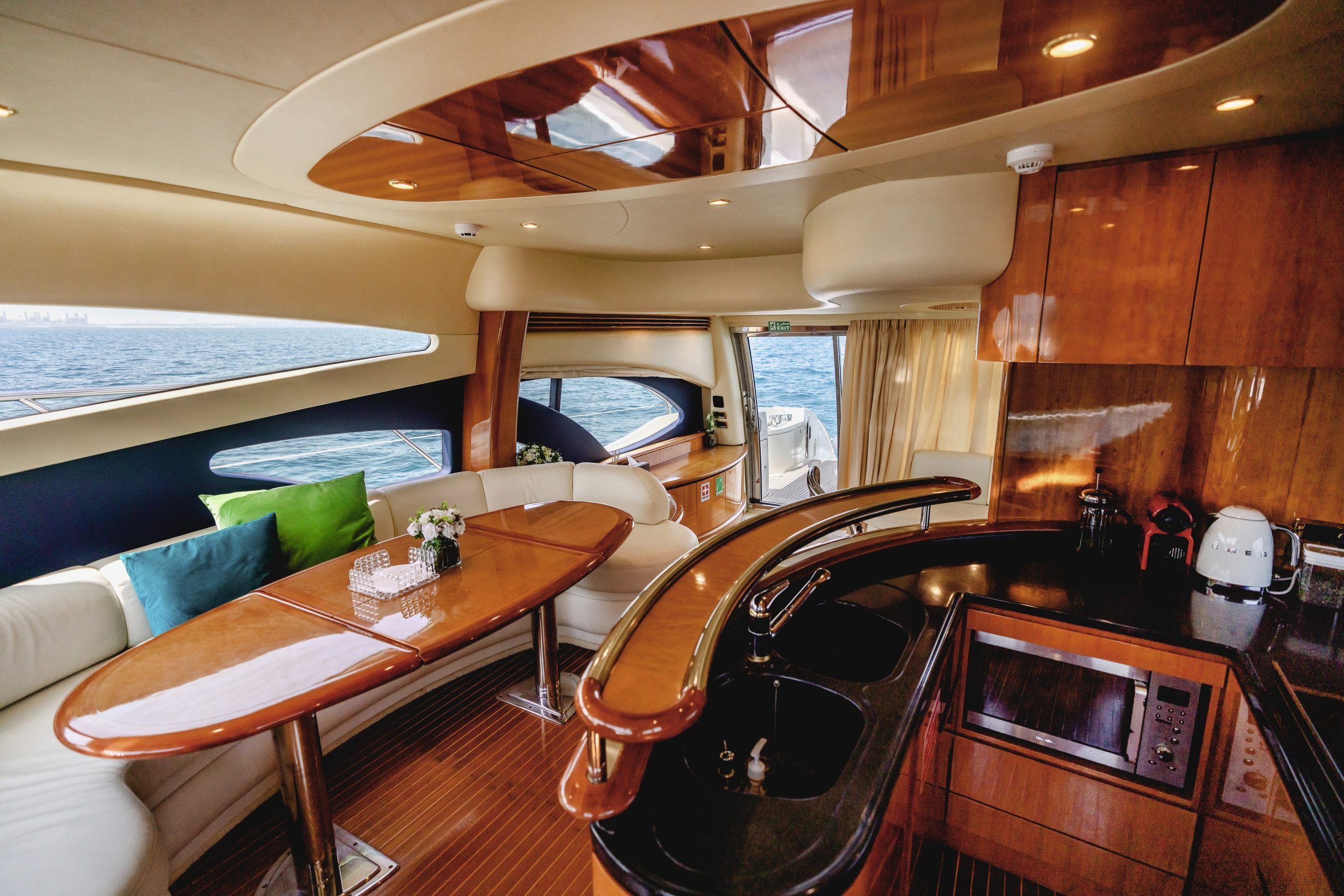 Dining table and kitchen galley inside Azimut 62 luxury yacht