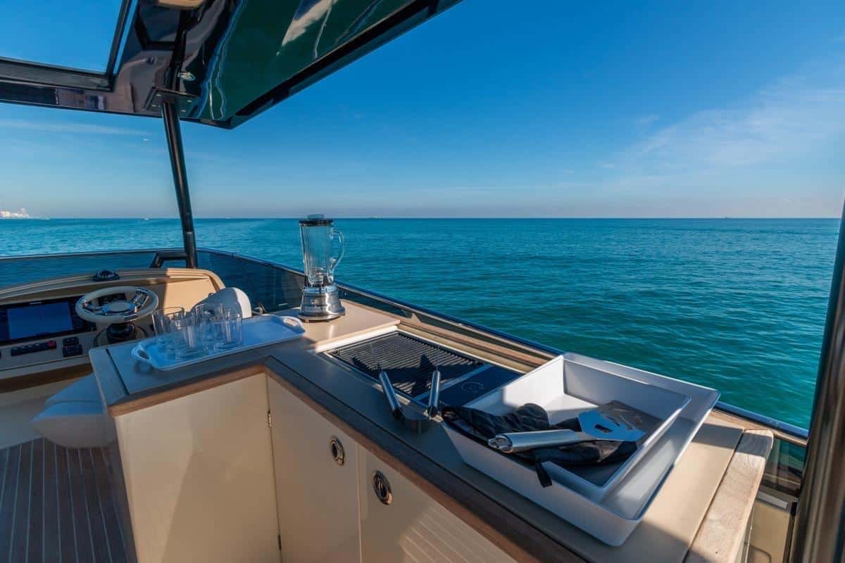 Monaco 60 yacht bow sunbeds with blue cushions overlooking Dubai waters