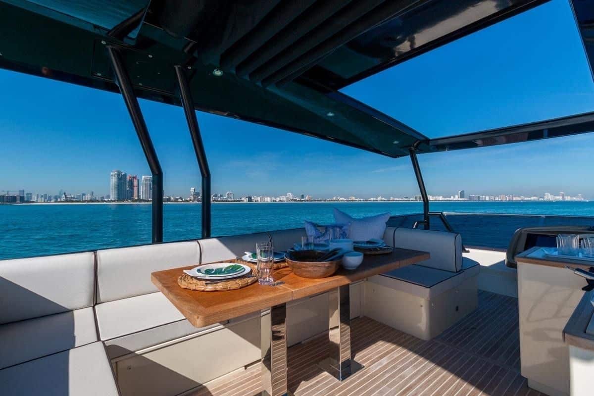 Monaco 60 yacht upper deck dining table under shaded canopy in Dubai