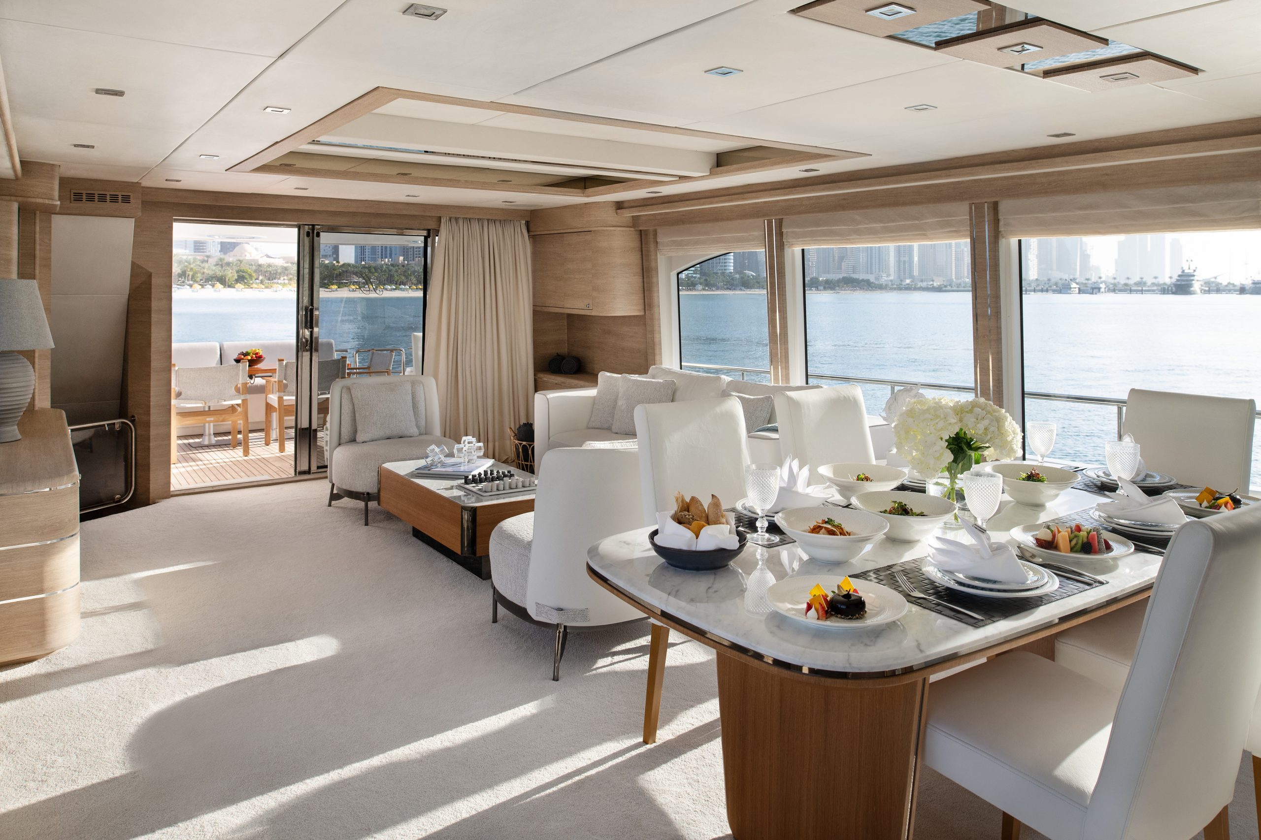 Luxury yacht indoor dining table setup with sea view in Dubai