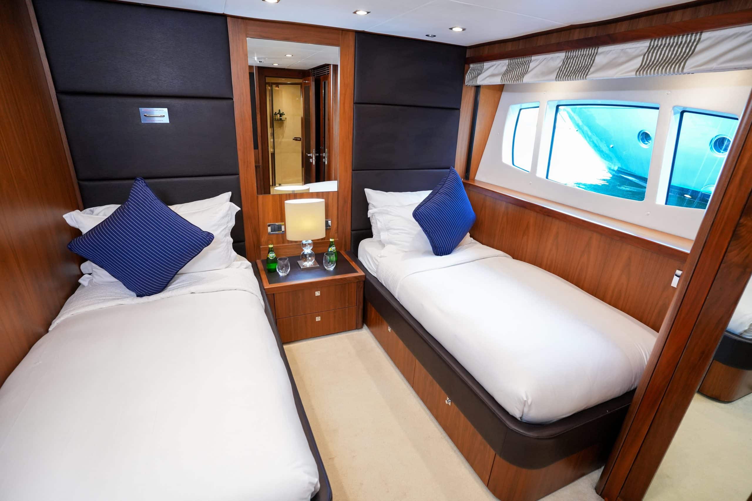 Twin guest cabin on Sunseeker 131 yacht with single beds and wooden interior finishes