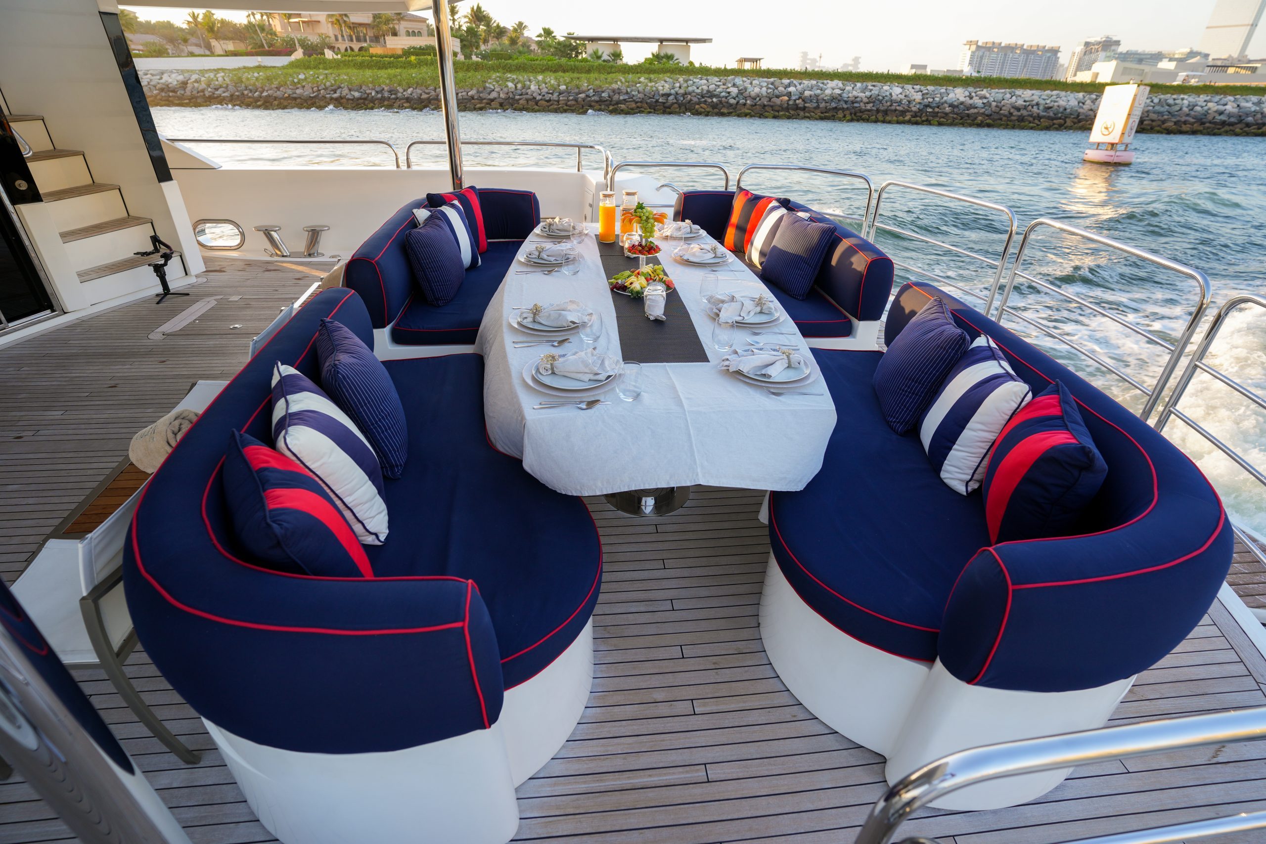 Circular outdoor lounge seating on Sunseeker 131 yacht with central table and city skyline