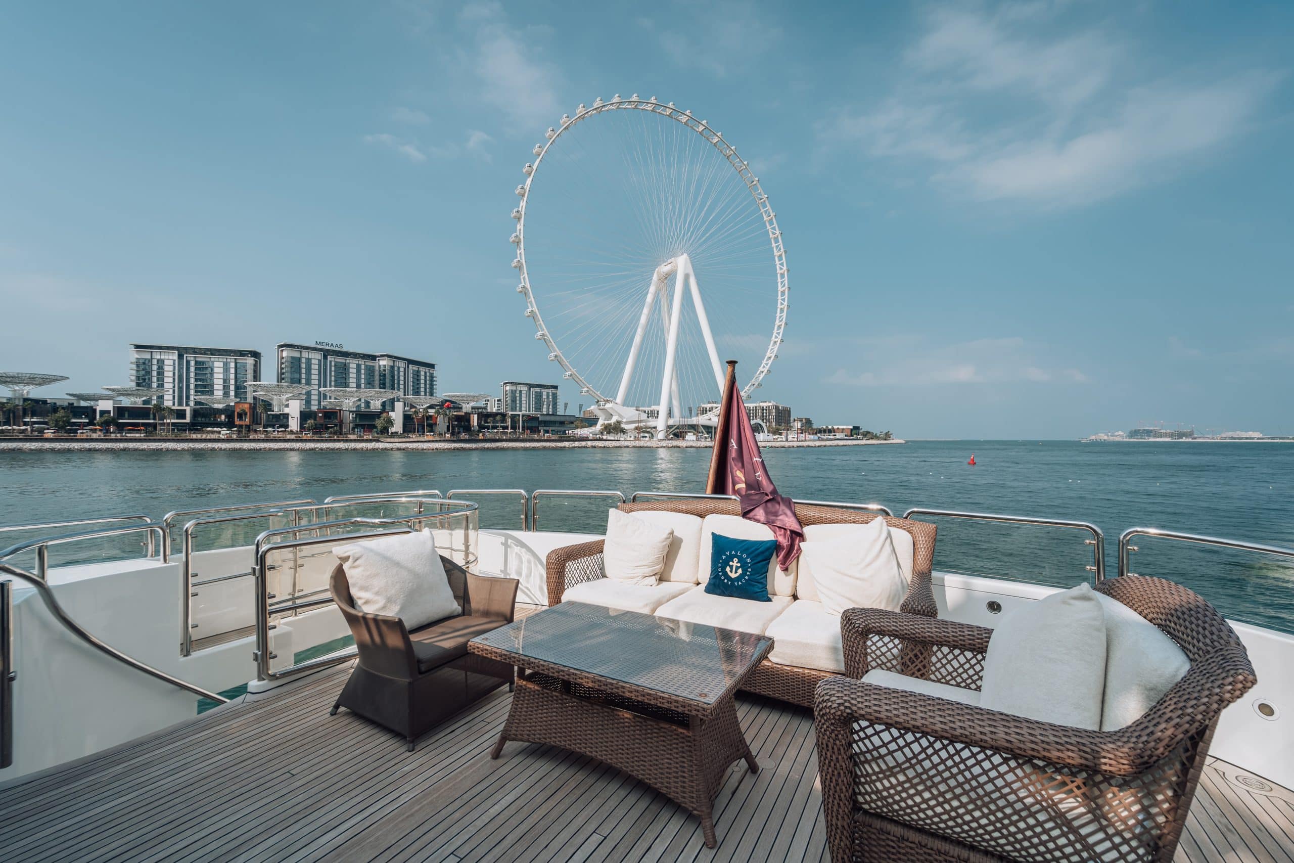 Yacht lounge seating area with sea view and Ain Dubai in the background, Dubai.