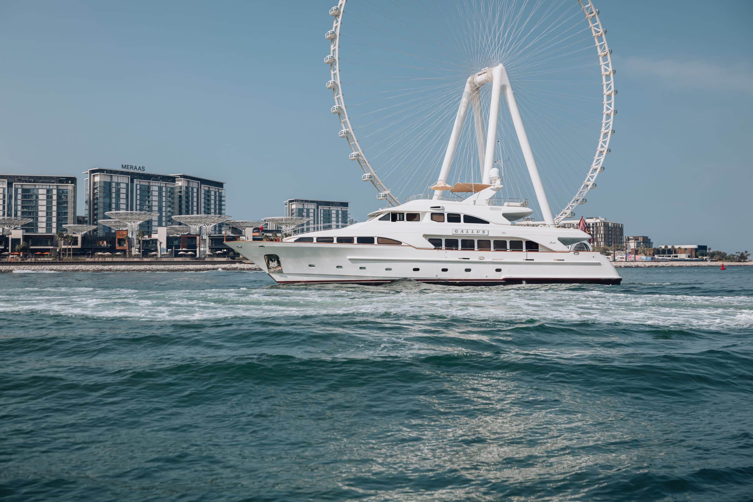 Luxury yacht cruising past Ain Dubai in Dubai.