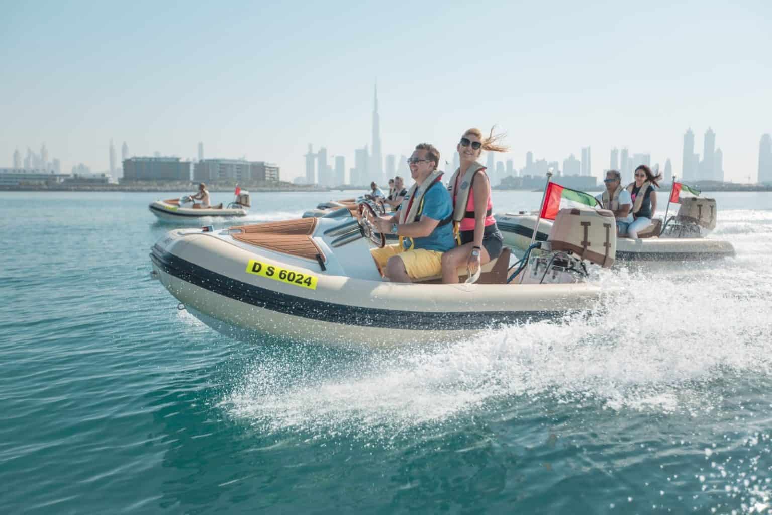 Tourists enjoying a self-driving speed boat ride in Dubai marina with skyline view