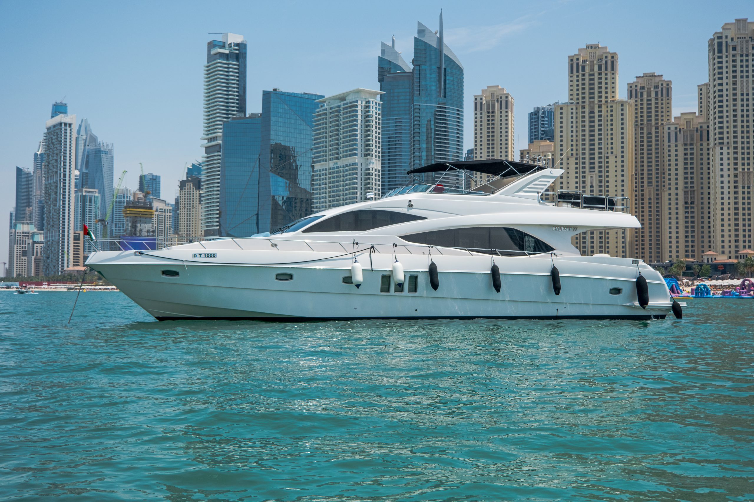 Cabo 77 yacht cruising in Dubai waters with skyline view