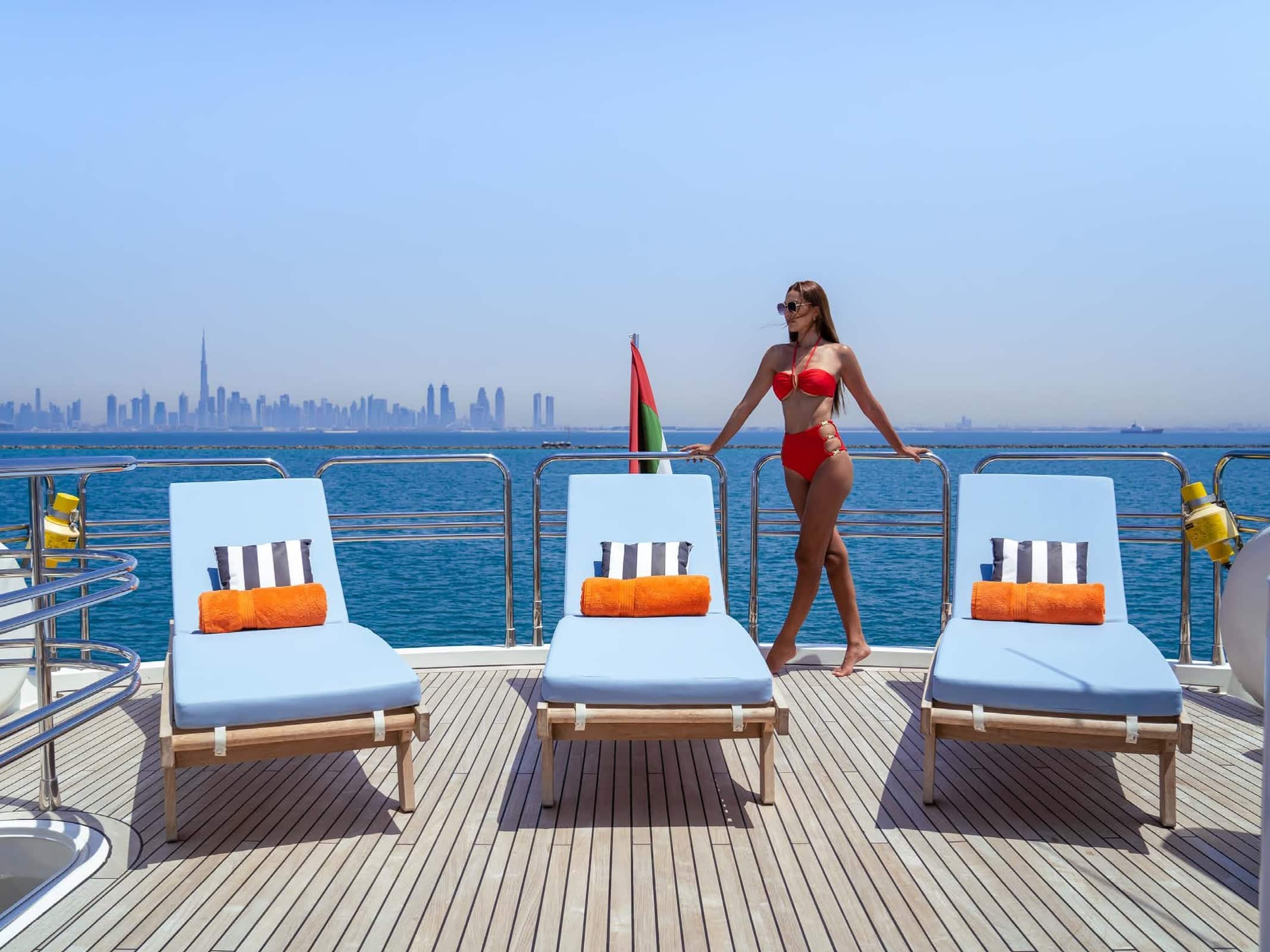 Guest walking on sun deck of Notorious luxury yacht with lounge chairs