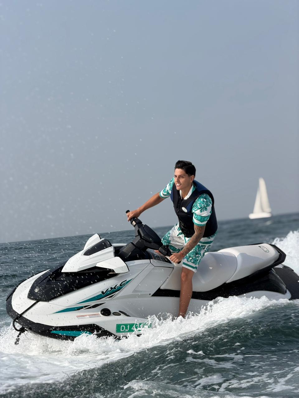 Jet ski rider cruising in Dubai waters with modern buildings in background