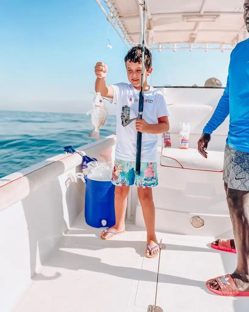 Professional crew assisting guest on private fishing boat in Dubai