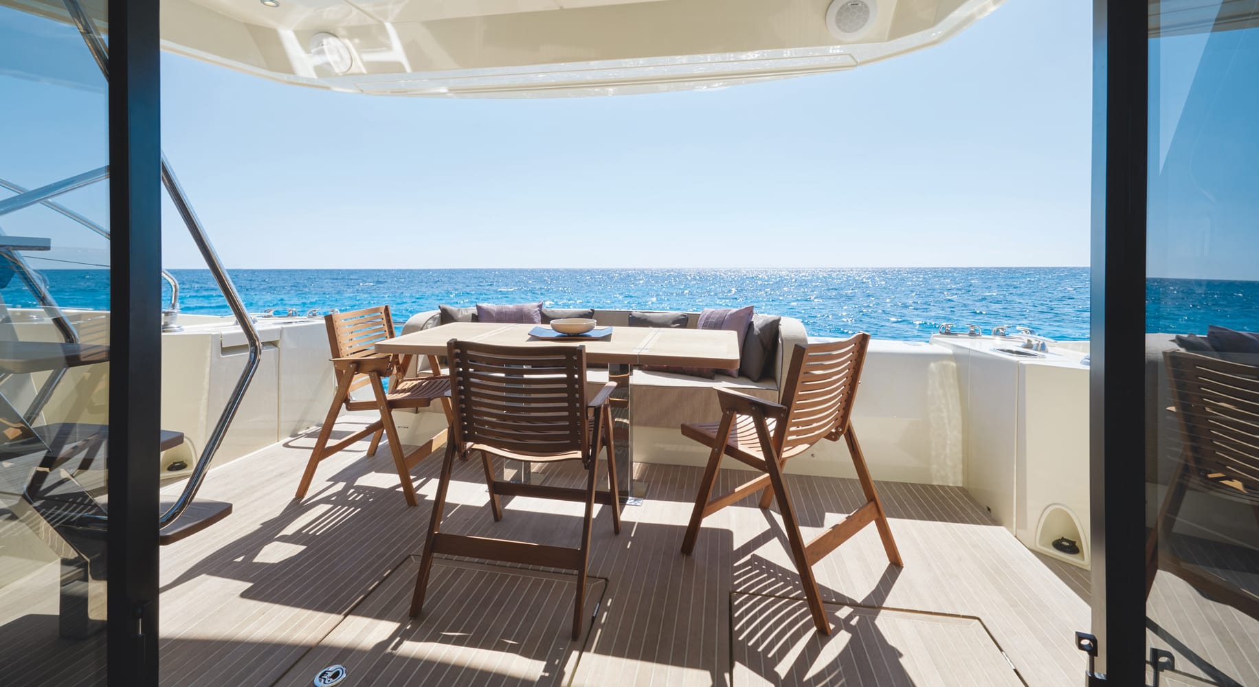 Monaco 60 yacht outdoor dining setup with wooden table and sea view