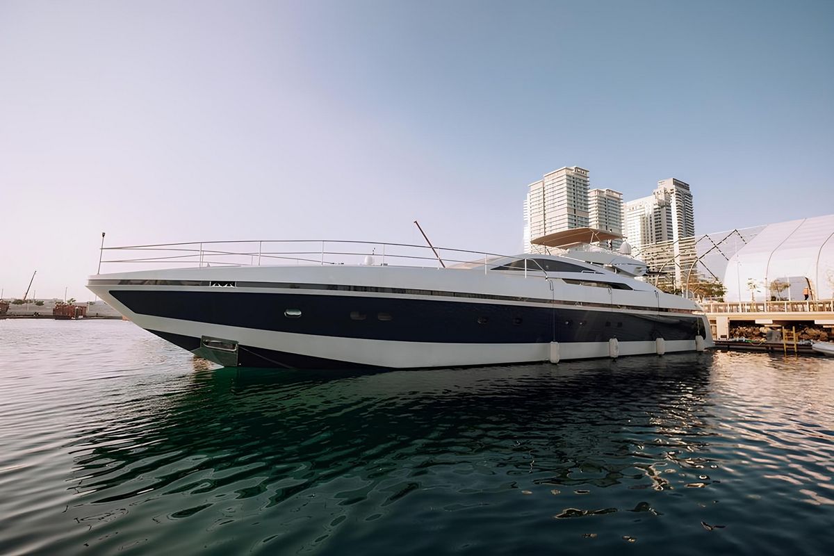 Baglietto 110 luxury yacht exterior side profile cruising on calm waters with modern city skyline backdrop
