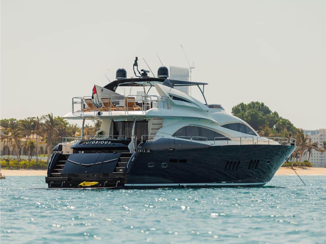 Notorious luxury yacht anchored on calm waters with swim platform