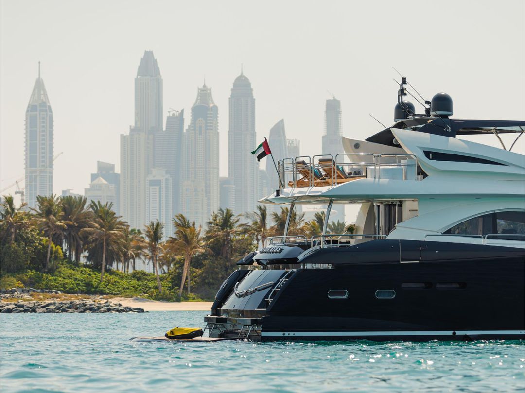 Notorious yacht cruising near Dubai skyline on clear day