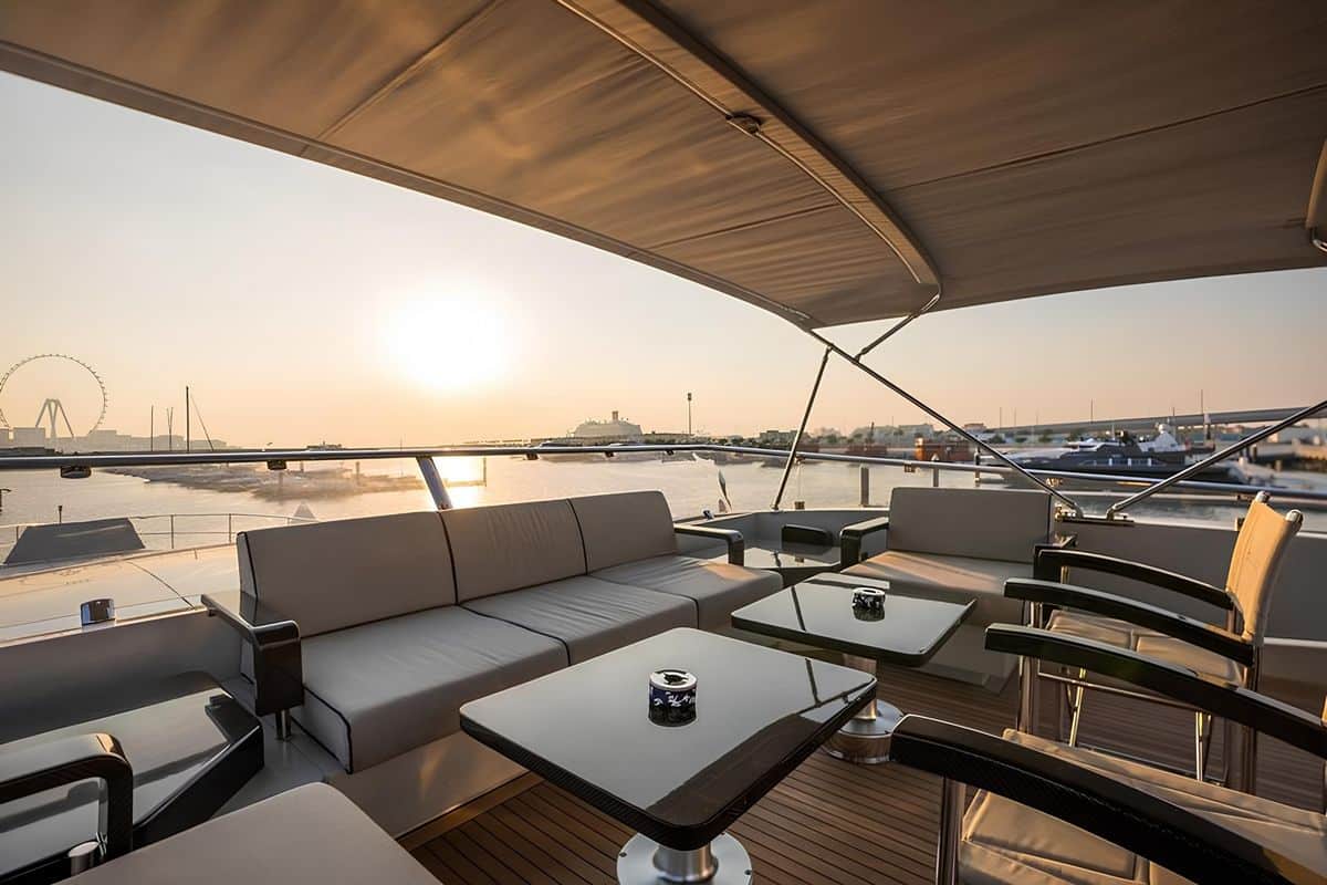 Baglietto 110 yacht upper deck lounge with cushioned seating, wooden ceiling and sunset sea views