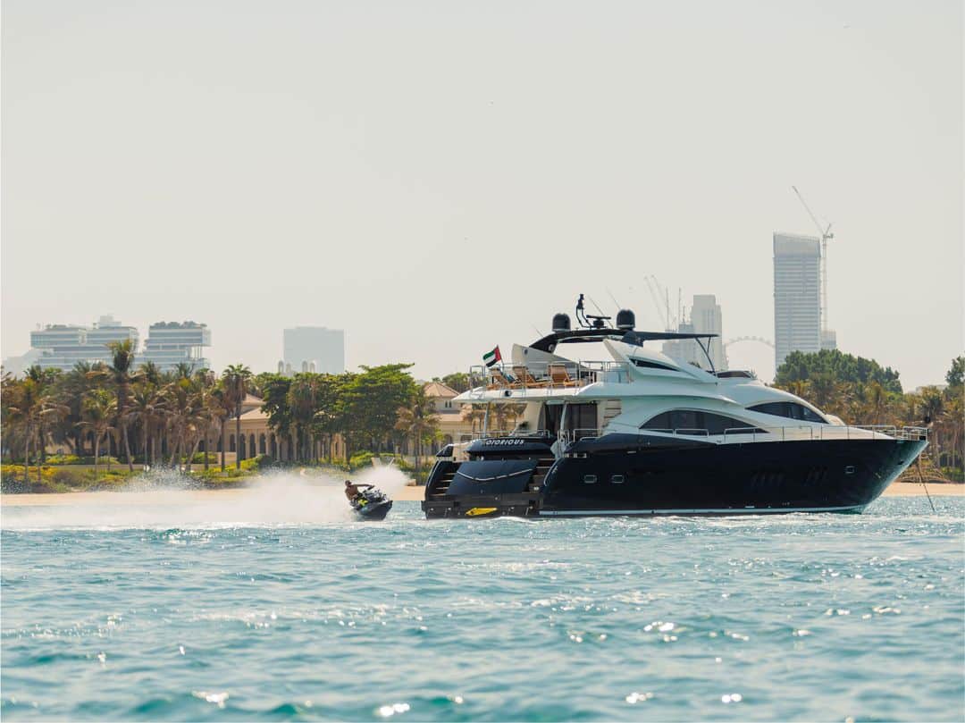Notorious luxury yacht cruising on open water near the city skyline