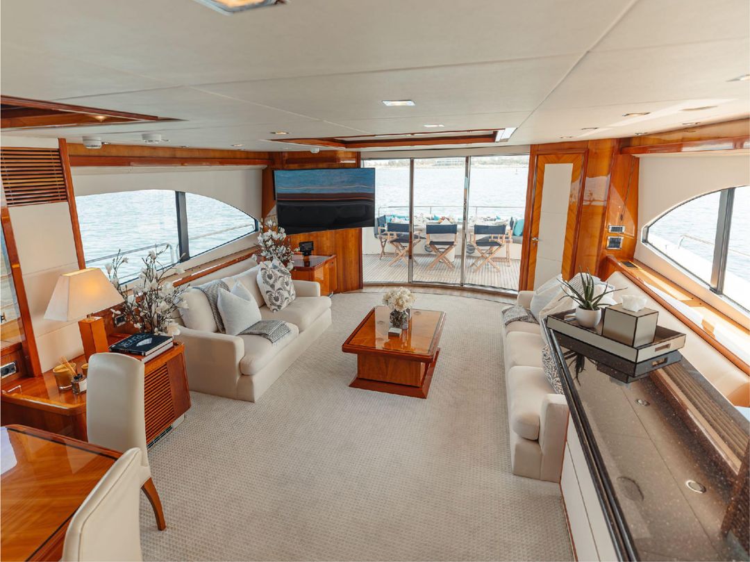 Interior lounge area of Notorious yacht with large windows and modern decor