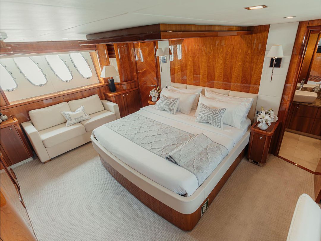 Master bedroom on Notorious yacht with large bed and wood paneling