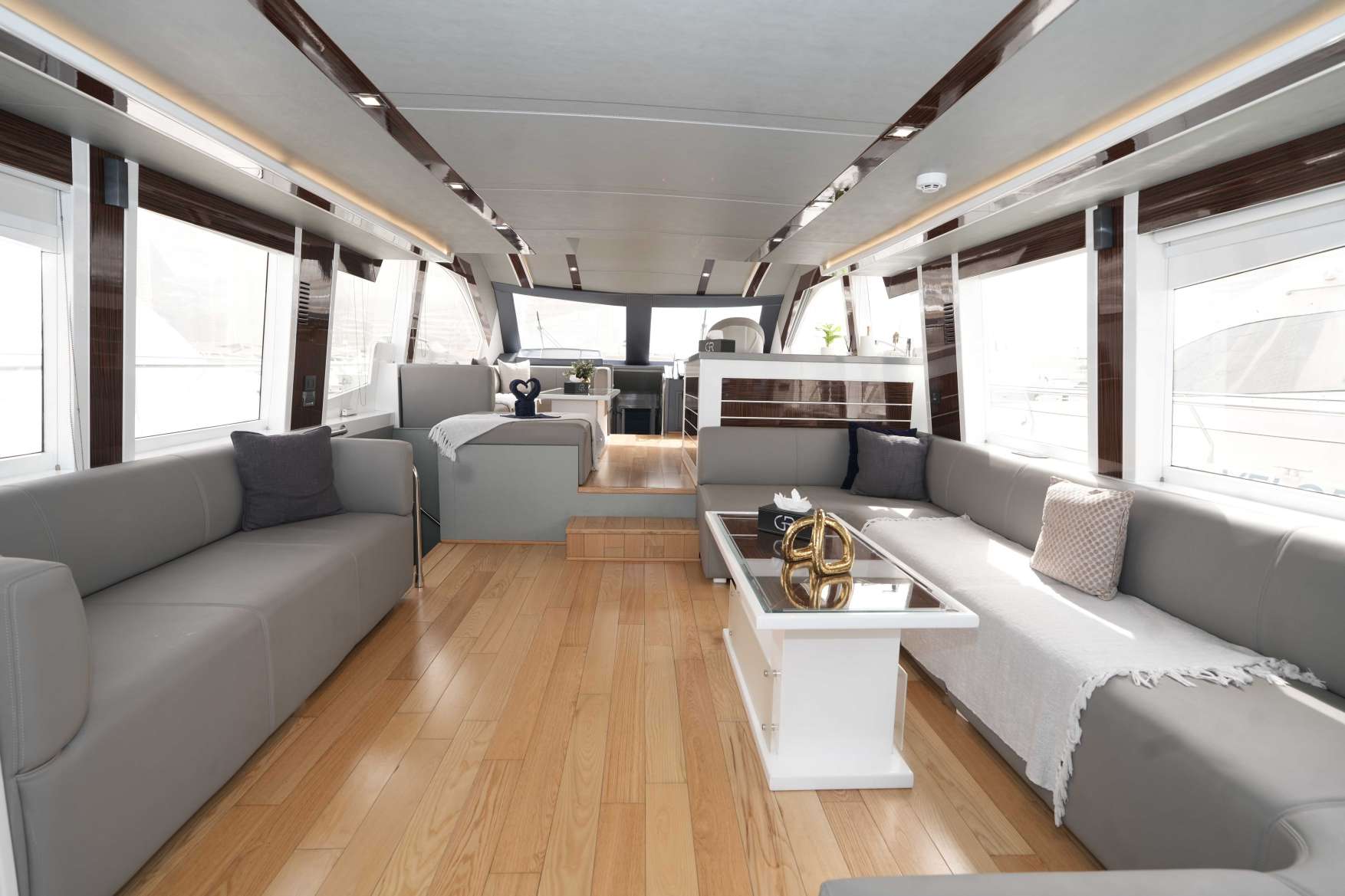 Belle 75 yacht interior with spacious lounge and wood flooring.