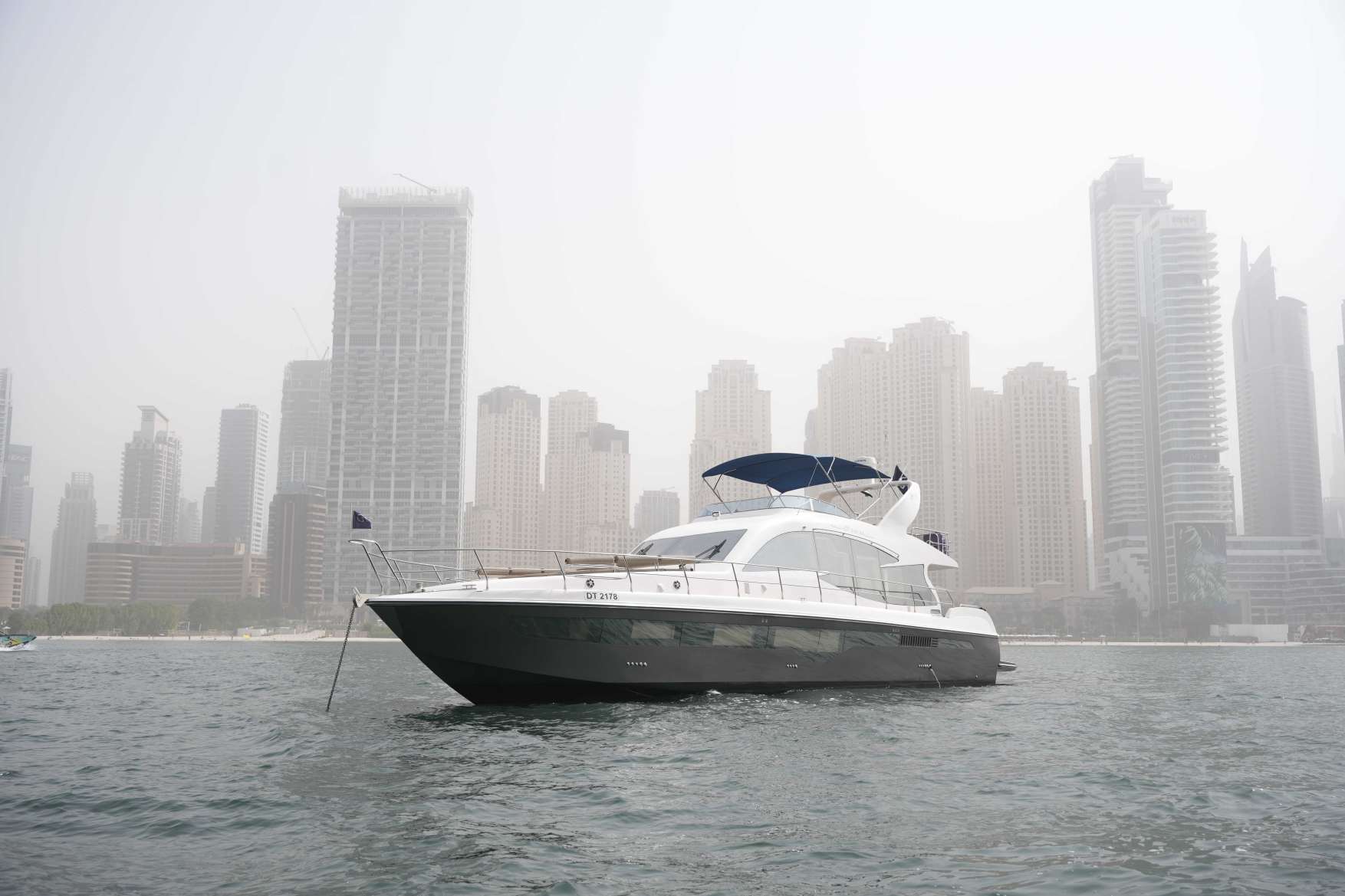 Belle 75 luxury yacht on the water with city skyline background