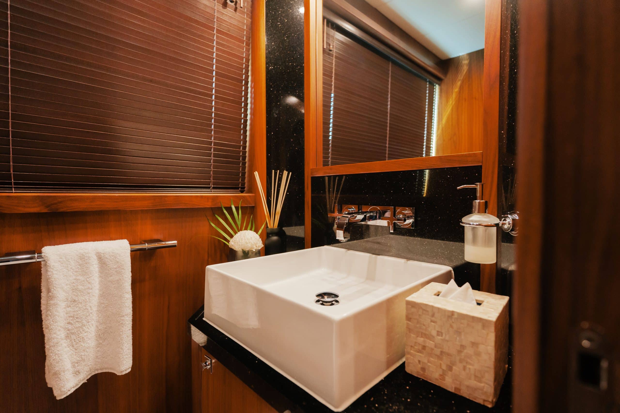 Aurora 130 yacht bathroom with marble countertop and wood cabinetry
