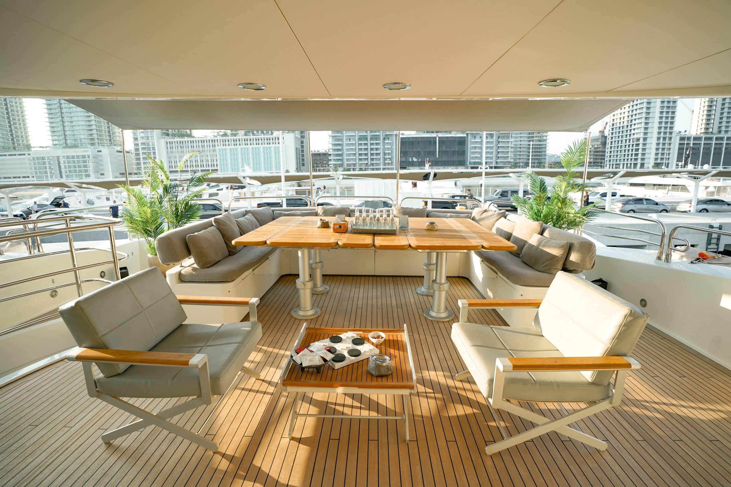 Aurora 130 yacht aft deck dining area with teak flooring and marina views