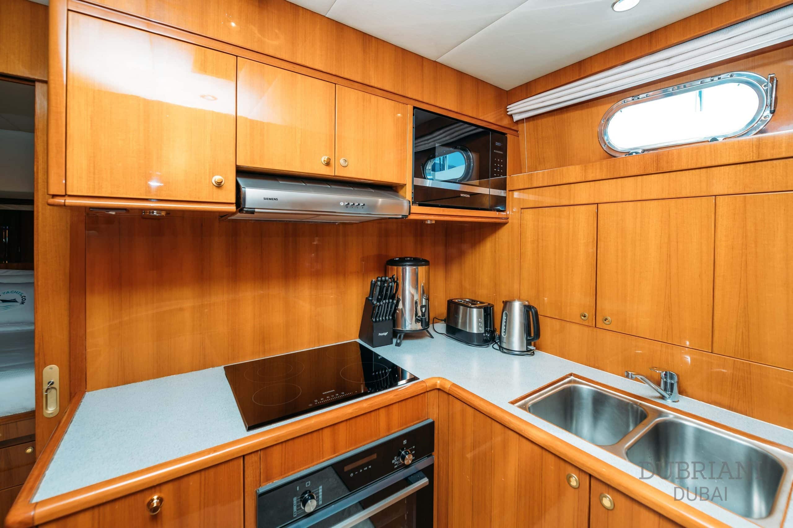 Fully equipped galley kitchen on Eclipse yacht with wooden cabinetry and modern appliances