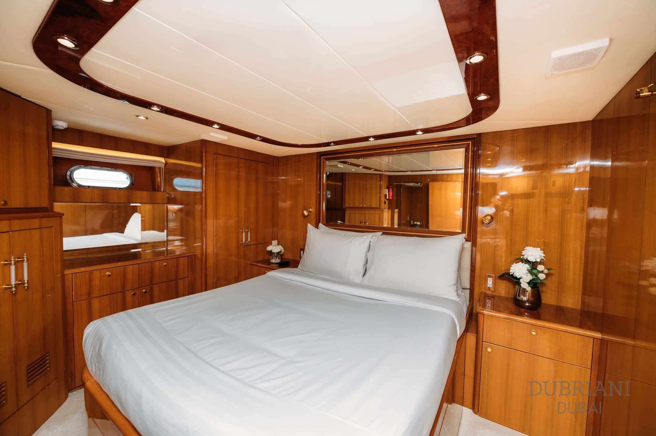 Luxury guest cabin bedroom on Eclipse yacht with queen bed and wood-paneled interior