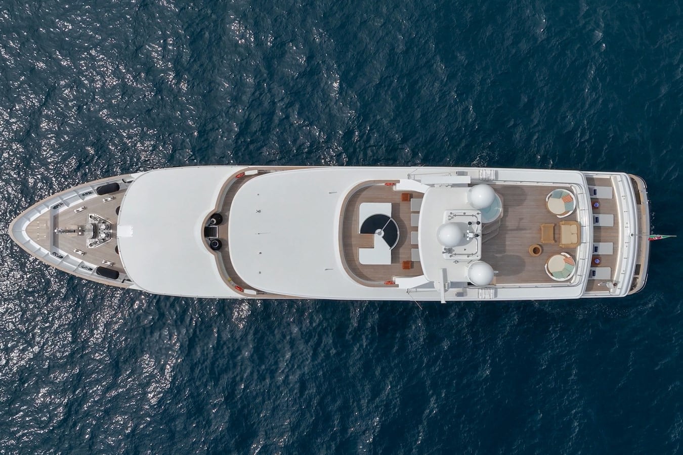 Overhead aerial view of the white 54m Baglietto superyacht at anchor on deep blue open water