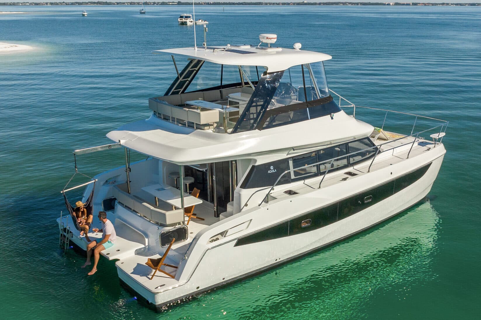 Aquila 42 power catamaran bow view running at dusk, shipyard photo