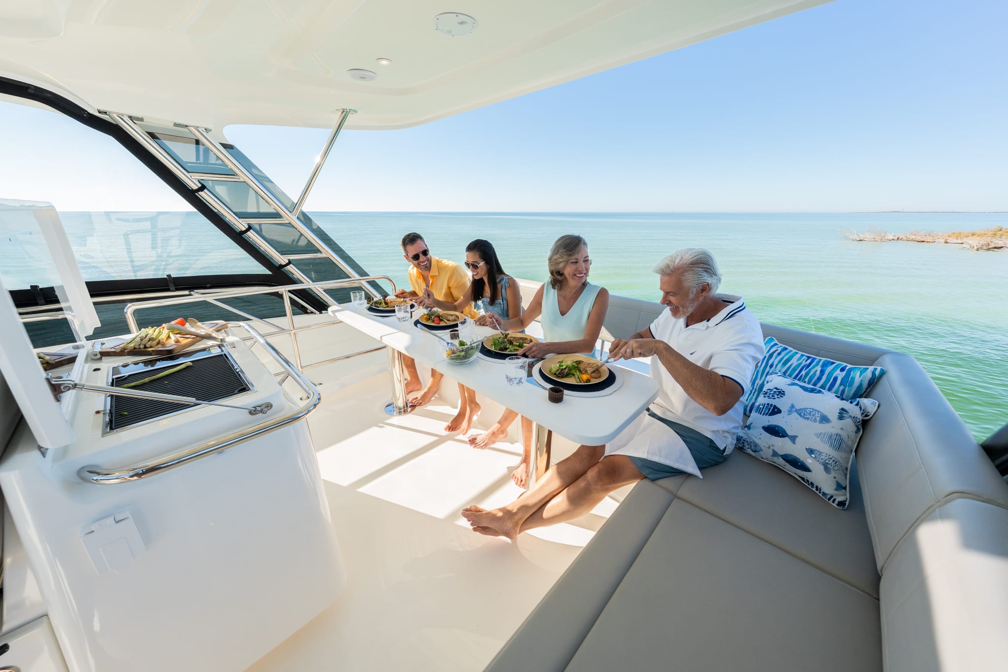 Aquila 42 flybridge dining with guests at anchor, shipyard photo