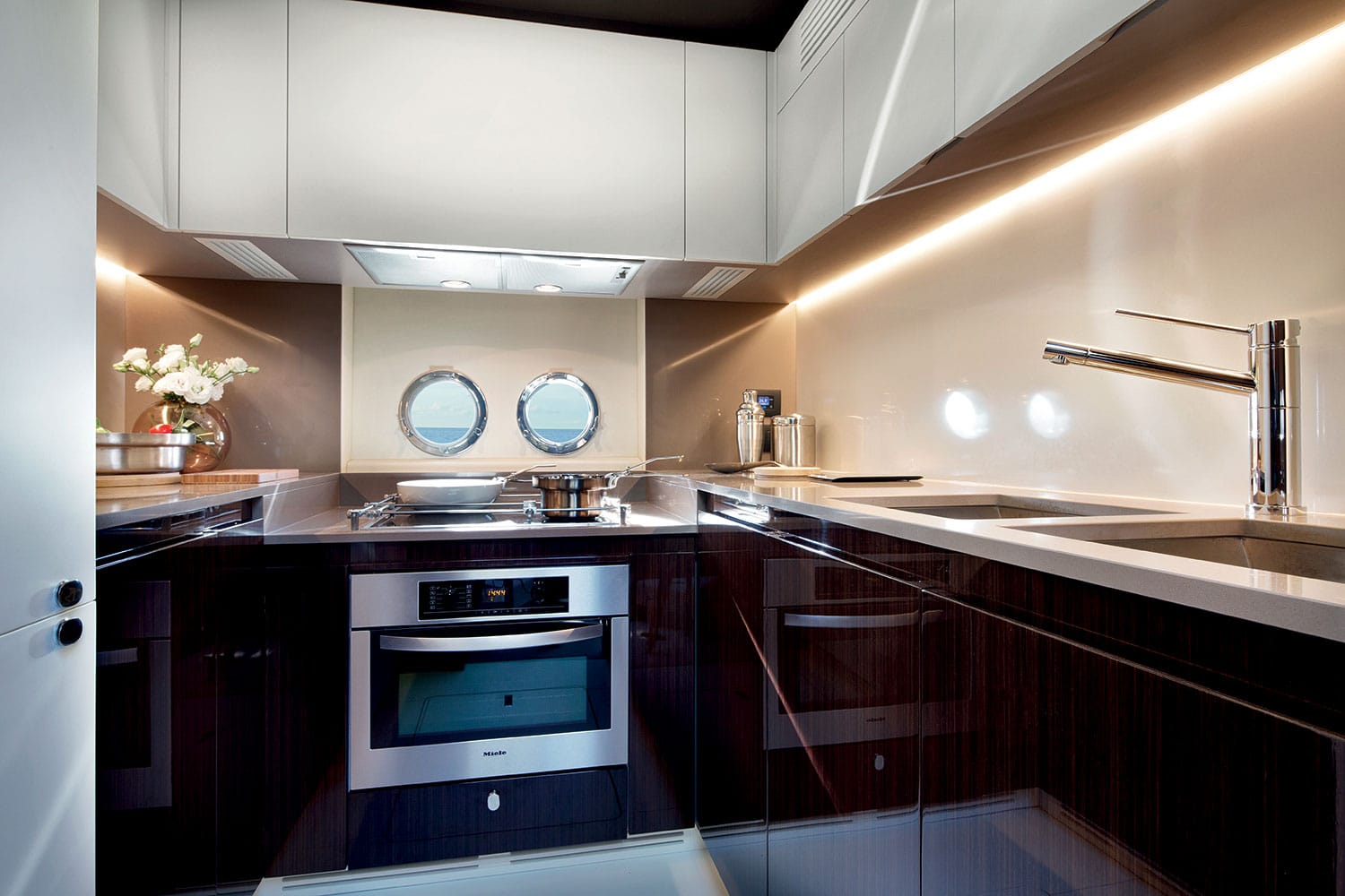 Azimut 77S galley with dark joinery and white worktops — shipyard photo