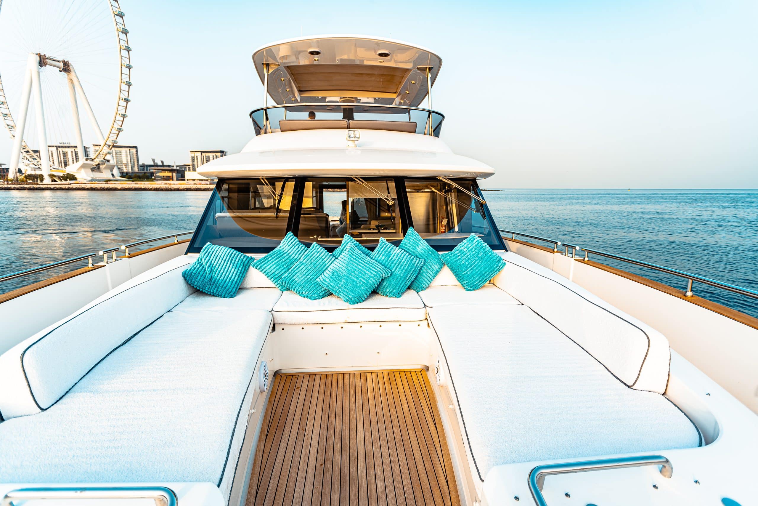Azimut Magellano 66 bow sunpad with turquoise cushions underway