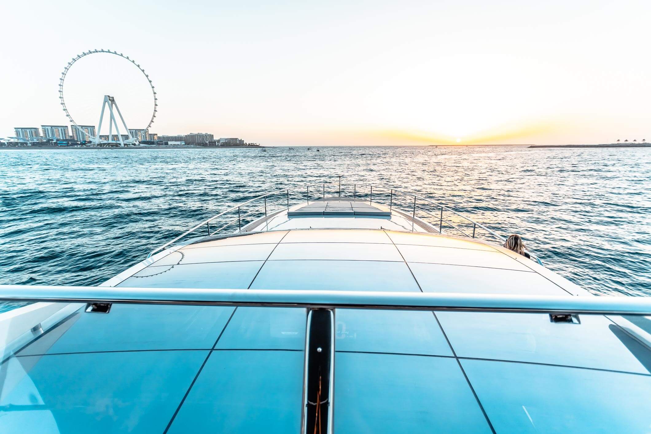 Baglietto 105 HT foredeck sunpads toward Ain Dubai at dusk