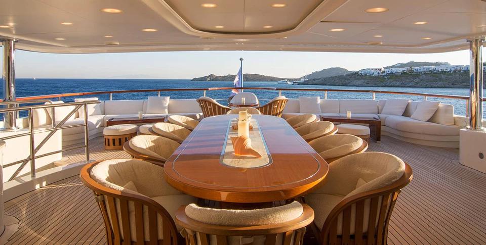 Benetti 56M covered aft deck with dining table for twelve guests
