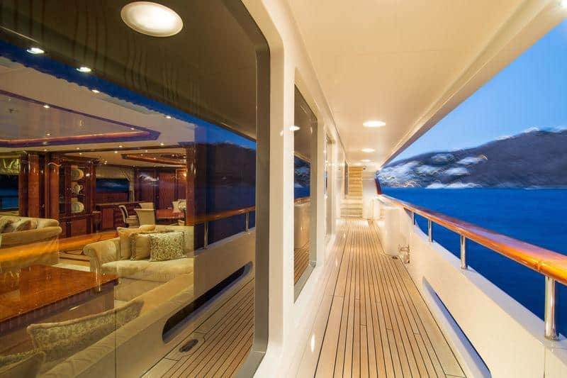 Benetti 56M side deck walkway at dusk with saloon glowing aft