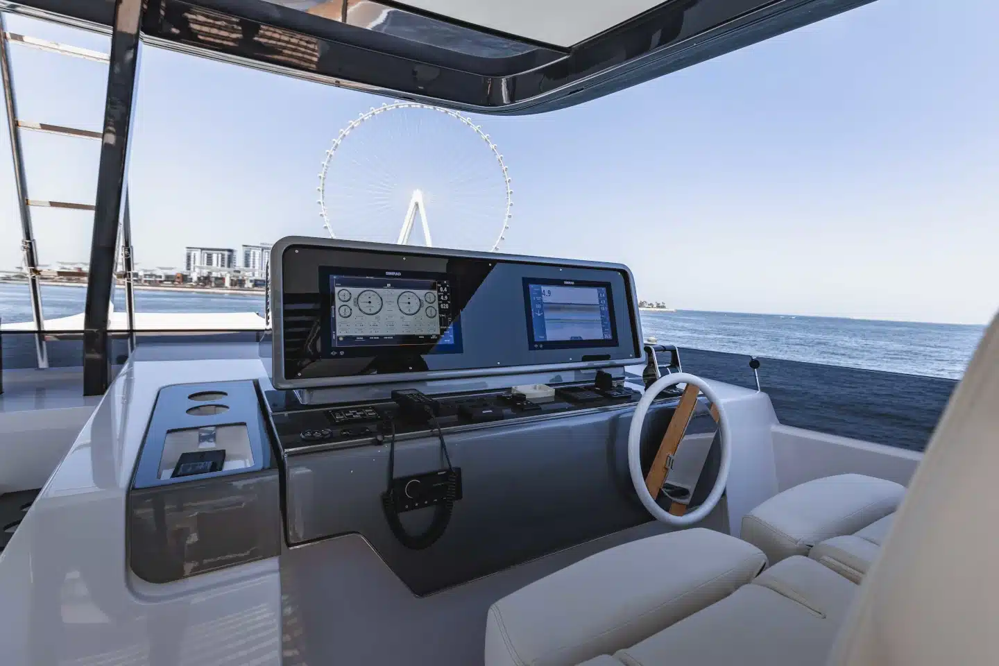 Ferretti 860 flybridge helm with Ain Dubai on the horizon
