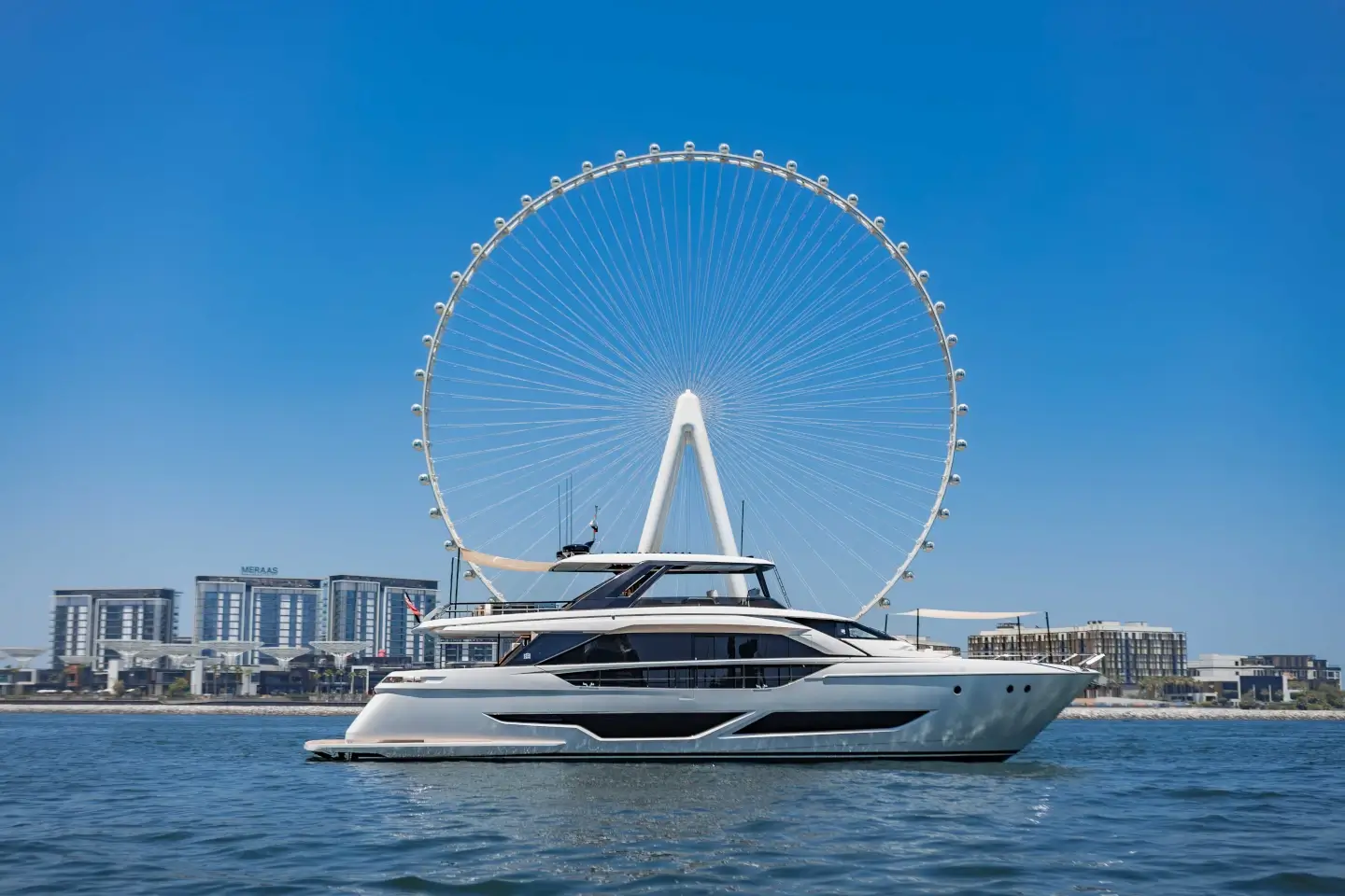 Ferretti 860 at anchor with Ain Dubai on the horizon