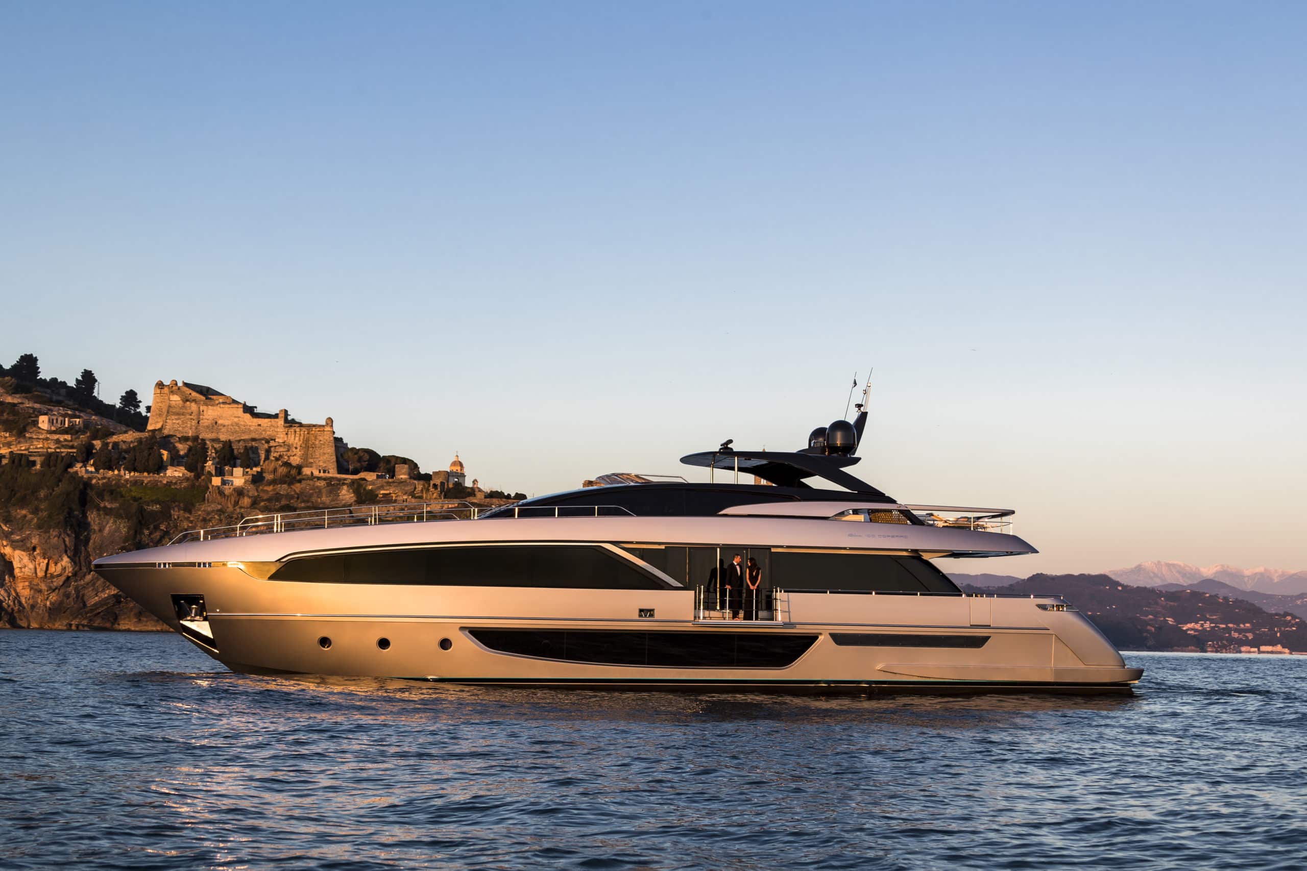 Riva 100 Corsaro at anchor at golden hour, balcony open, press photo