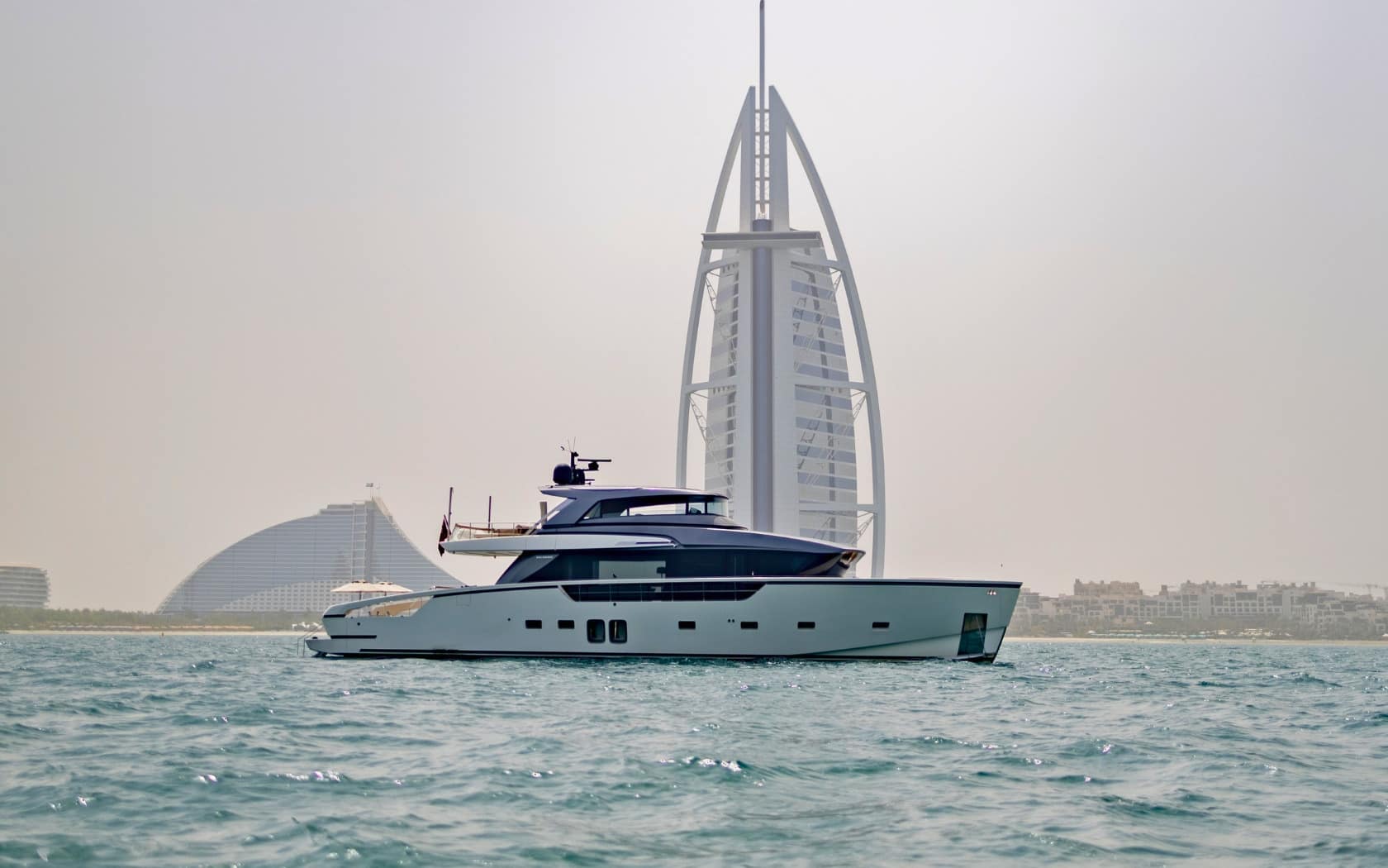 SanLorenzo SX88 profile at anchor off Dubai — Burj Al Arab astern