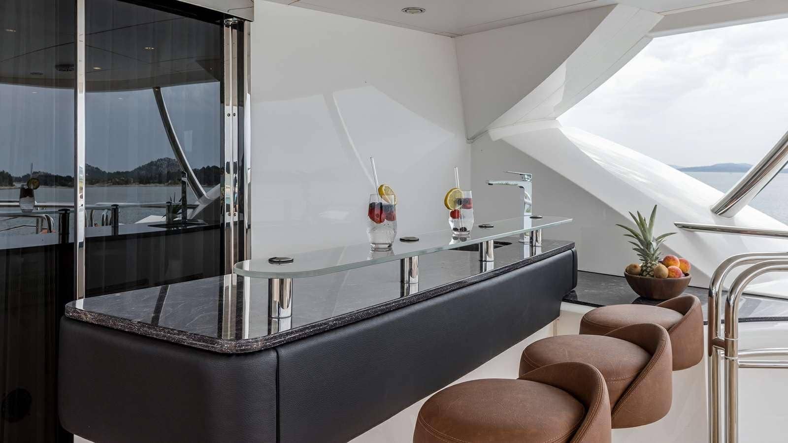 Sunseeker 37M aft deck bar counter with cocktails and bar stools