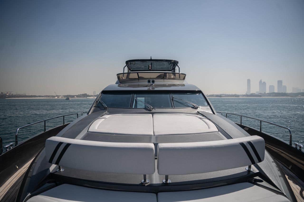 Sunseeker 82 Yacht bow view with foredeck sunpads, Dubai skyline